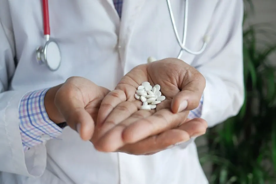 A close-up of a doctor holding white pills in their palms, emphasizing healthcare and medicine.